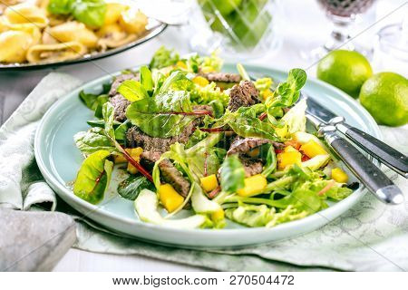 Fresh Salad Plate With Mixed Greens Arugula, Mesclun, Mache On Dark Wooden Background Close Up. Manz