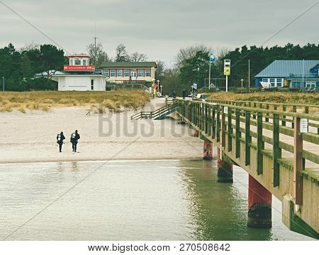 Prerow Germany - January 25 2018: Couple Of Sea Divers Walk From Sea To Beach. End Of Diving Lesson.