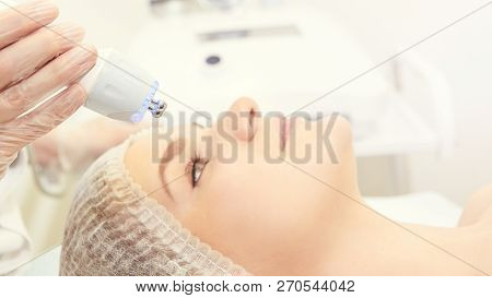 Facial Micro Current Cosmetology Procedure. Beauty Technology Treatment. Woman Face Therapy