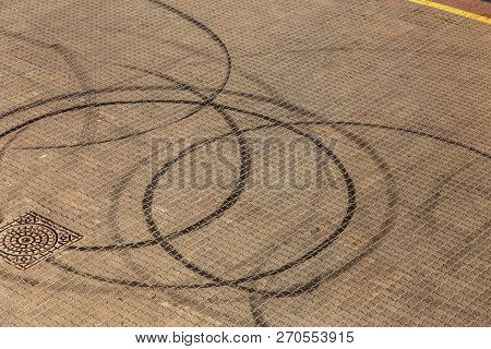 Abstract Transport Background With Pivoting Black Tire Track Over Asphalt Road Surface. Trace Of Dri
