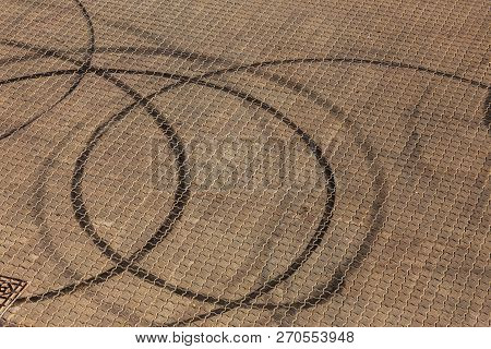 Abstract Transport Background With Pivoting Black Tire Track Over Asphalt Road Surface. Trace Of Dri