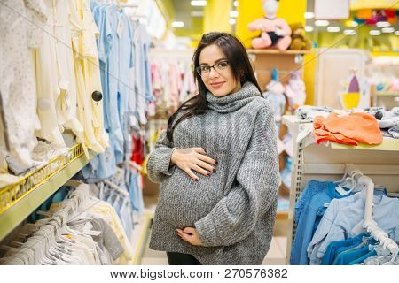 Pregnant woman buying clothes in the store
