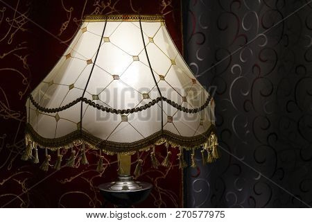 Glowing Lamp On A Night Background Curtained Windows