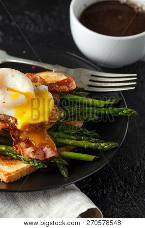 Benedict Poached Duck Egg With Crispy Bacon And Fried Asparagus On Toasts For Breakfast