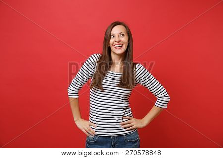 Portrait Of Dreamy Pretty Young Woman In Striped Clothes Looking Up, Standing With Arms Akimbo Isola
