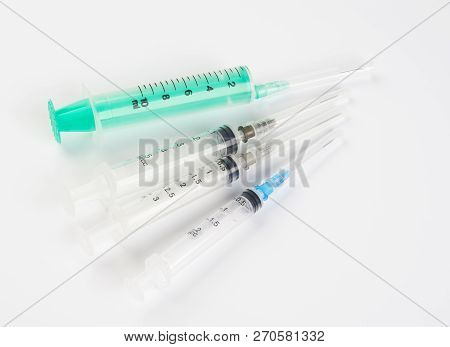 A Set Of Disposable Syringes For Injections Of Different Sizes On A White Background.