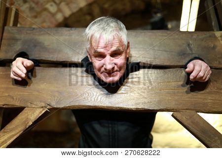 Portrait Of Elderly Man In A Wooden Pillory