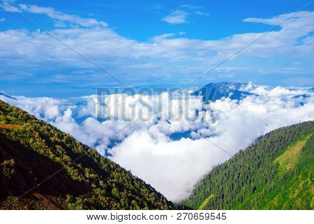 Landscape - View From The Mountain Top On A Sunny Day To The Valley Hidden By Low Clouds