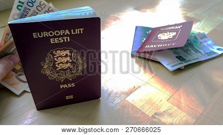 Passports On The Wooden Background. Citizenship Of Estonia And Russia. Citizenship Of European Union