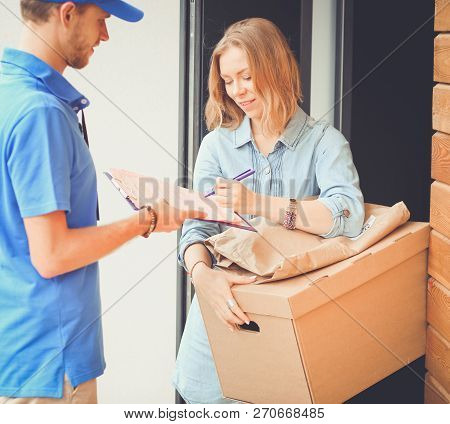 Smiling Delivery Man In Blue Uniform Delivering Parcel Box To Recipient - Courier Service Concept. S