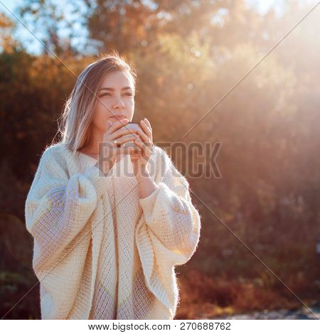 Beautiful Admiring Woman Drinking Hot Tea From Thermos Cup With Backligth Sun.