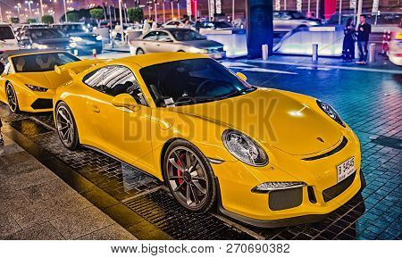 Dubai, Uae - December 23, 2017: Luxury Supercar Porsche 911 Carrera 4 Gts Yellow Color Parked Next T