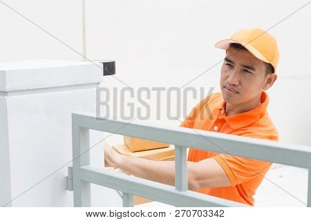 Delivery Man Ring A Bell To Call Customers For Receive A Parcel At Front Home