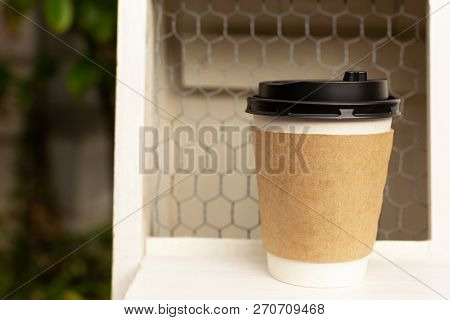 Take Away Cup Of Coffee On The Shelf. Coopy Space For Your Text. Empty Coffee Sleeve For Your Brand.