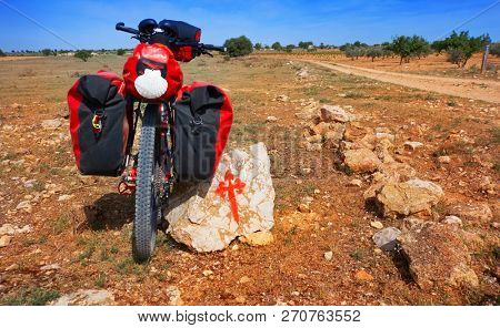 Saint James Way pilgrim bike and Templarios cross sign by Camino de Santiago of spain
