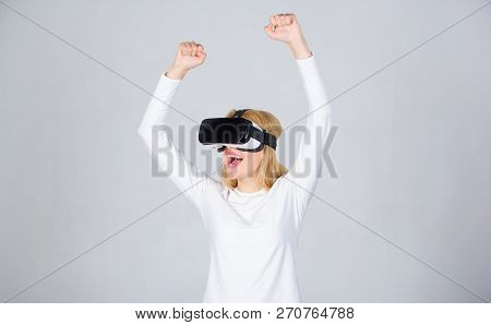 Portrait Of Woman In A White Blouse With Virtual Reality Glasses On Head Isolated On Grey Background