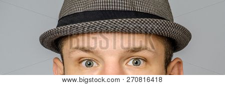 Close-up Portrait Of Young Male With Hat On Gray Background