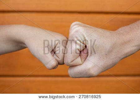 Power Five, Fist Bump Or Brofist. Close-up Of Child And Adult Fists Touching Each Other