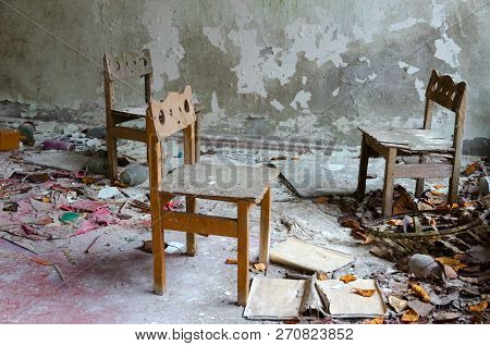 Small Wooden Chairs Among Dirt And Debris In Abandoned Kindergarten, Dead City Of Pripyat, Chernobyl