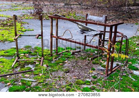Rusty Metal Frame Of Table And Chair In Schoolyard In Dead Abandoned Ghost Town Of Pripyat In Cherno
