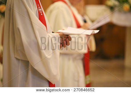 Young Priest With A Cassock And Hands Joined In Prayer During Holy Mass