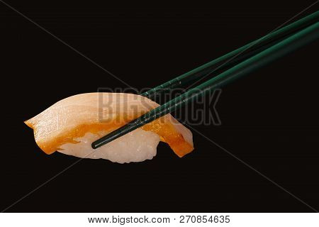 Hashi Hold Sushi And Rolls Isolated Over Black Background