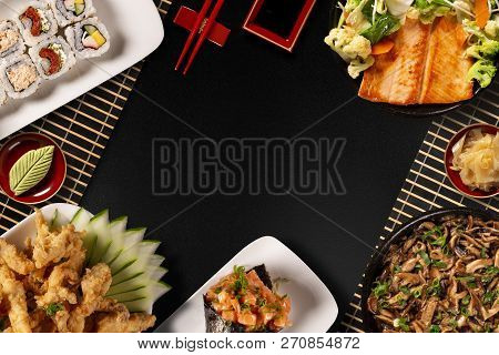 Japanese Food Composition. Various Kinds Of Sushi Placed On Black Stone Board. Spicy Kimchi Salad, C
