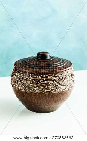 Pots And Plates Of Clay On A White Table And A Blue Background. Clay Pottery Kitchen Utensils Made B