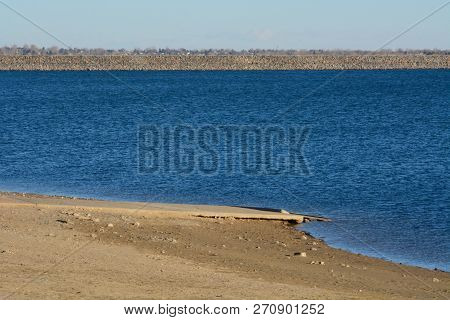 Empty Colorado Lake Water Reservoir Landscape With Low Water Level And Dock Removed For Winter Closu