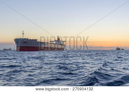 Huge Ships At Sea At Sunset With Orange Sky Bacjground