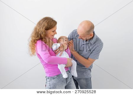 Family, Childhood And Parenthood Concept - Father, Mother Holding Cute Baby Over White Background