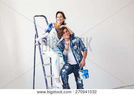 Renovation, Repair And Family Concept - A Young Couple Doing A Repair In New Home