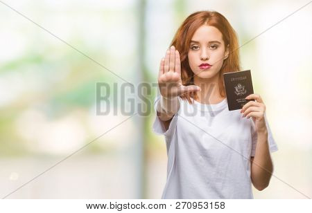 Young beautiful woman holding passport of united states of america over isolated background with open hand doing stop sign with serious and confident expression, defense gesture