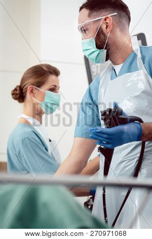 Team of doctors performing endoscopy in hospital examining stomach of patient 