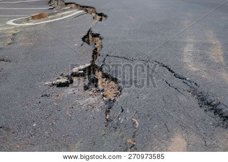 Crack On Asphault Rural Road. Damaged Collapsed Street
