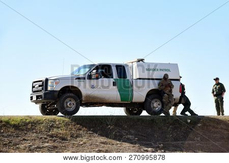 SAN YSIDRO, CALIFORNIA - NOVEMBER 26, 2018: Border Patrol Agents and Vehicle taking a break on the border between the USA and MExico.