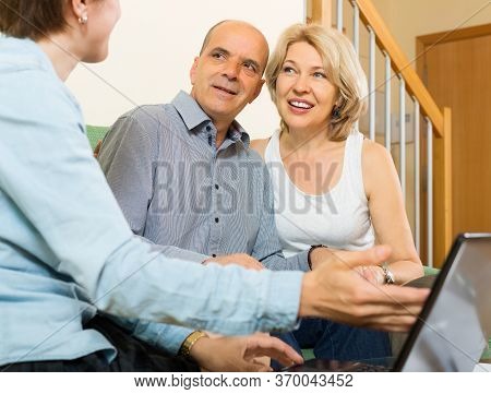 Happy Couple Answer Questions Of Social Worker At Home
