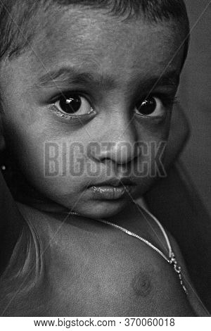 Monochrome Portrait Of 2 Year Old Indian Kid From Kerala With Added Grain And Noise.