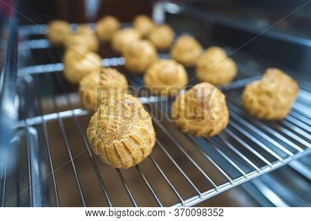 Close Up Choux Baked Home Made  Fresh Crispy Eclairs And Profiteroles. Making Desserts And Sweets On