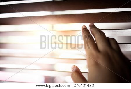 Hand Opening Sunblind Inside The  House. Sunlight Through The Window