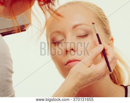 Two Women, Face Painting. Makeup Artist Applying Make Up To Model Face. Cosmetic Beauty Procedures, 