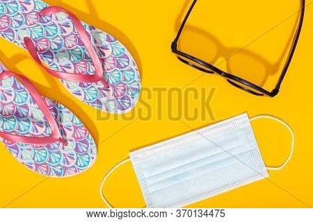 Flat Lay Composition With Summer Vacation Accessories And Face Mask On Yellow Background. Summer Or 
