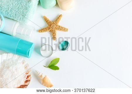 Spa Cosmetics And Towel With Sea Stars And Salt In The Scallop Shell On A White Background On Top