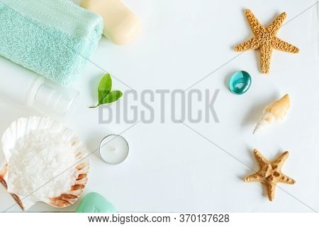 Spa Cosmetics And Towel With Sea Stars And Salt In The Scallop Shell On A White Background On Top