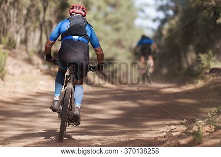 Athletes Mountain Biking On Forest Trail, Mountain Bike Race