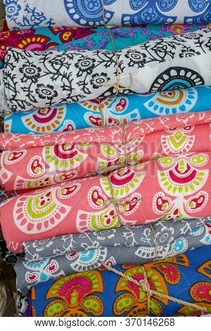 Rolled Up Colored Fabrics Tied With String. Shop With Brightly Colored Sarongs. Sarung Pantai Ready 