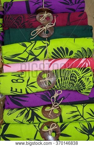 Batik Cloth Cloth For Sale Rolled Up In Market. Balinese Art And Culture. Close Up Of Rolled Colorfu