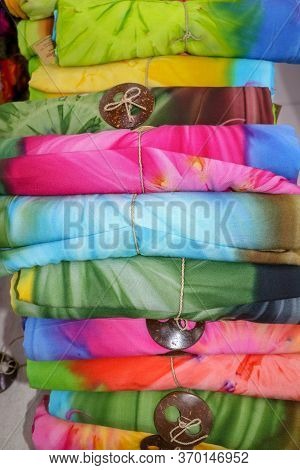 Batik Cloth Cloth For Sale Rolled Up In Market. Balinese Art And Culture. Close Up Of Rolled Colorfu