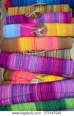 Batik Cloth Cloth For Sale Rolled Up In Market. Balinese Art And Culture. Close Up Of Rolled Colorfu