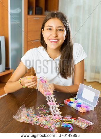 Happy Girl Makes Braslets With Elastic Rainbow Loom Bands